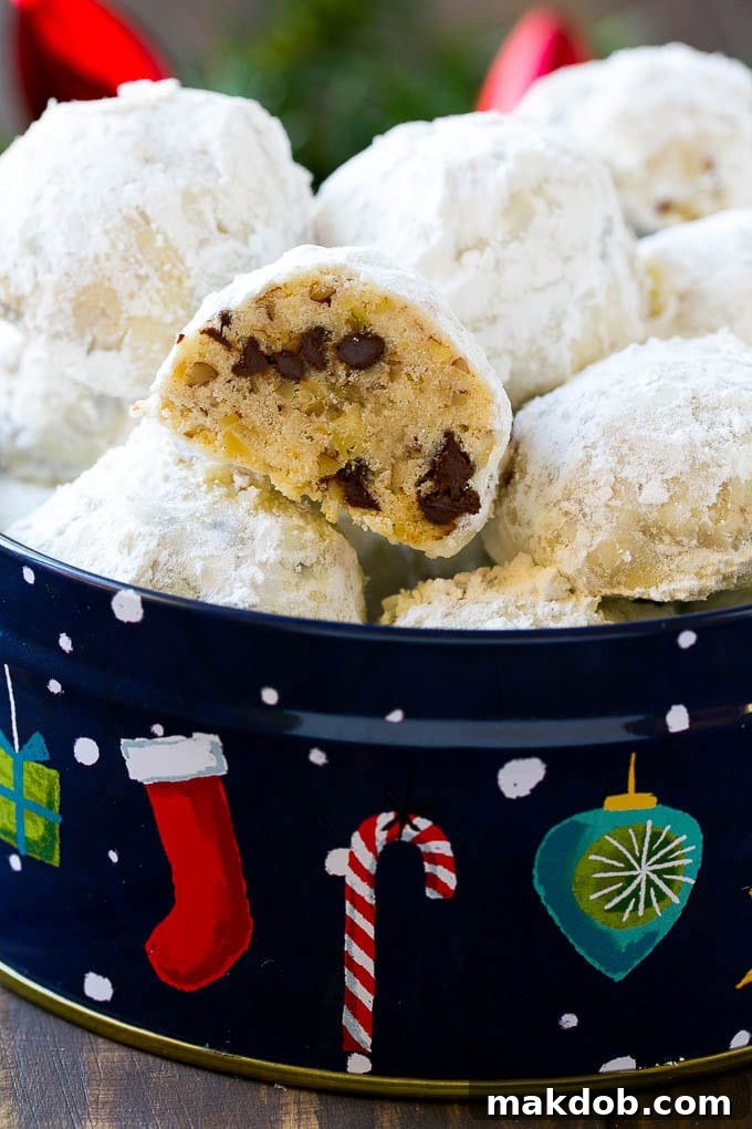 Snowball Cookies Recipe | Mexican Wedding Cookies | Russian Tea Cakes #cookies #pecan #chocolate #baking #dessert #christmas #dinneratthezoo A cross-section view of a pecan chocolate snowball cookie, revealing the rich, buttery interior studded with chopped pecans and mini chocolate chips.