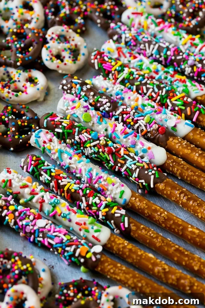 A sheet pan with coated twists and rods decorated with rainbow sprinkles.