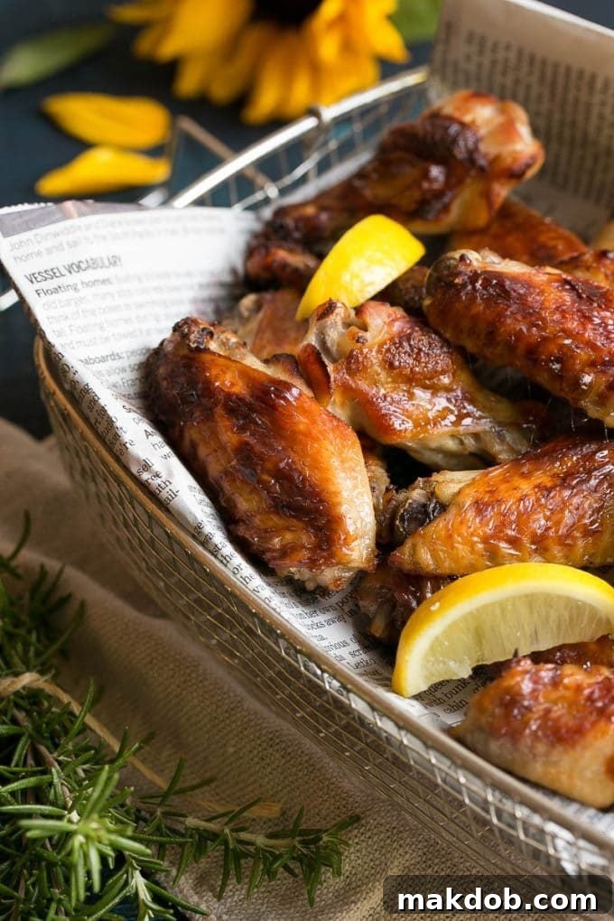 Baked chicken wings with vibrant lemon wedges in a rustic serving basket, ready to be enjoyed.