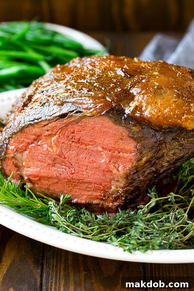 A smoked prime rib roast cooked to medium-rare on a serving platter, garnished with fresh herbs.
