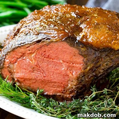 A smoked prime rib roast cooked to medium rare on a serving platter.