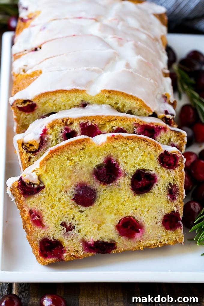 Slices of cranberry bread elegantly topped with a generous drizzle of orange glaze.