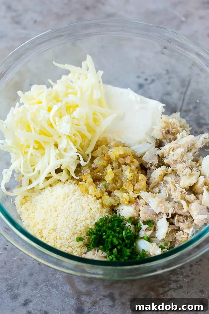 A bowl showcasing the creamy, rich filling mixture of crab meat, three cheeses, chives, onions, and garlic.