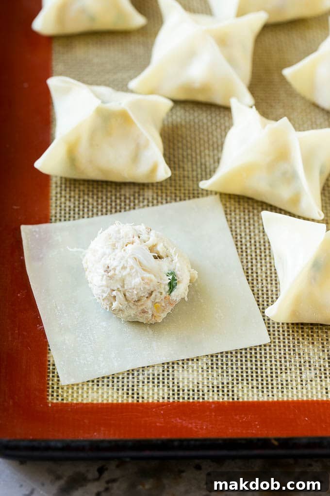 Crab Rangoon Recipe | Crab Wontons | Cream Cheese Wontons #crab #cheese #appetizer #snack #chinesefood #dinner #dinneratthezoo A single wonton wrapper with a perfect dollop of creamy crab filling centered, ready for folding.