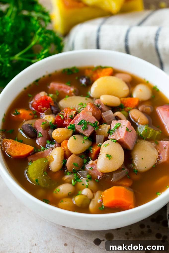 A bowl of ham and bean soup made with dried beans, ham and vegetables, then topped with fresh parsley.