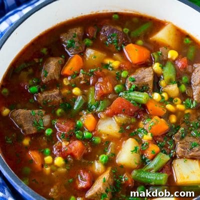 Vegetable beef soup made with chunks of beef, carrots, potatoes, green beans, corn and peas, a perfect hearty meal.