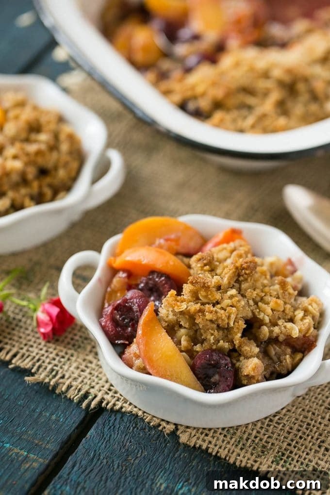 A charming ramekin showcasing a single serving of golden-brown fruit crisp, garnished with fresh berries.