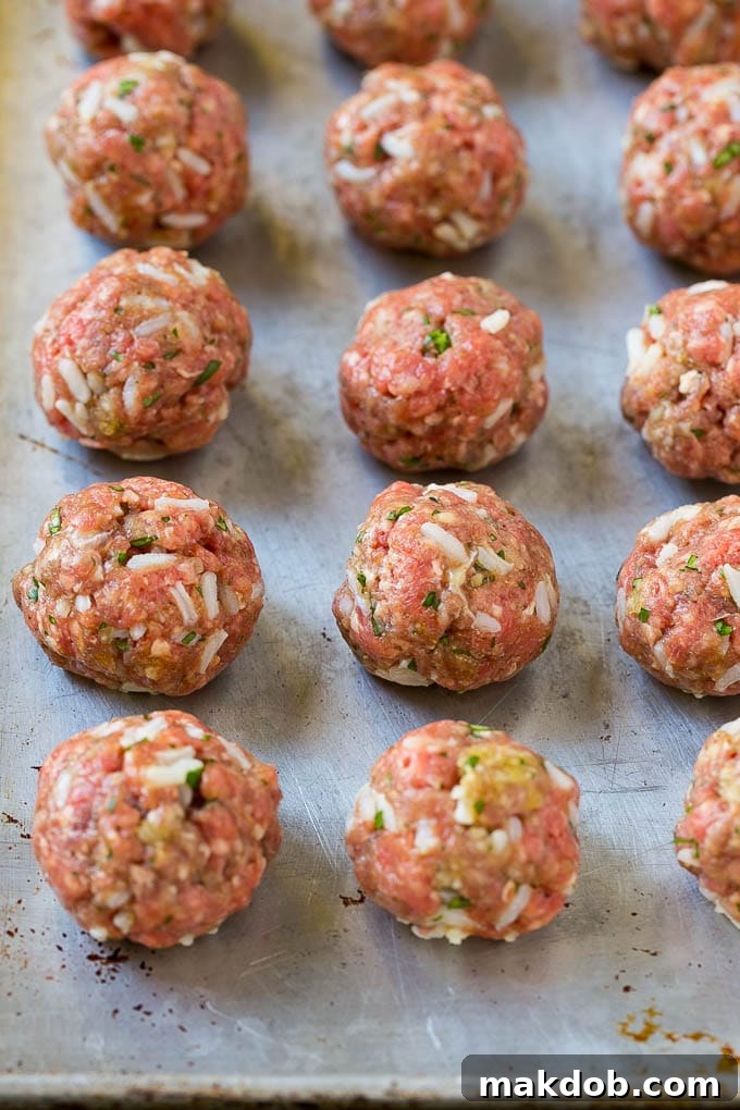 Albondigas Soup | Meatball Soup | Mexican Soup #soup #meatballs #beef #rice #glutenfree #dinner #dinneratthezoo #comfortfood Uncooked beef and rice meatballs on a sheet pan.