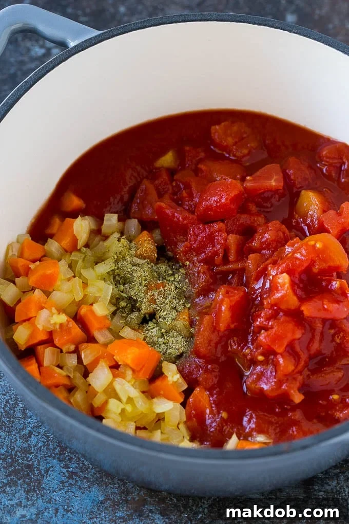 Albondigas Soup | Meatball Soup | Mexican Soup #soup #meatballs #beef #rice #glutenfree #dinner #dinneratthezoo #comfortfood Vegetables, tomatoes and herbs in a soup pot.