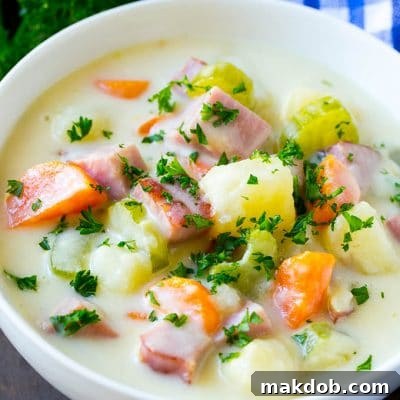 A bowl of ham and potato soup loaded with veggies in a creamy broth.