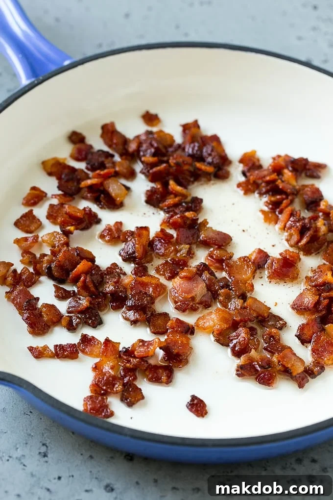 Sizzling bacon cooking in a skillet, turning perfectly crisp for the carbonara.