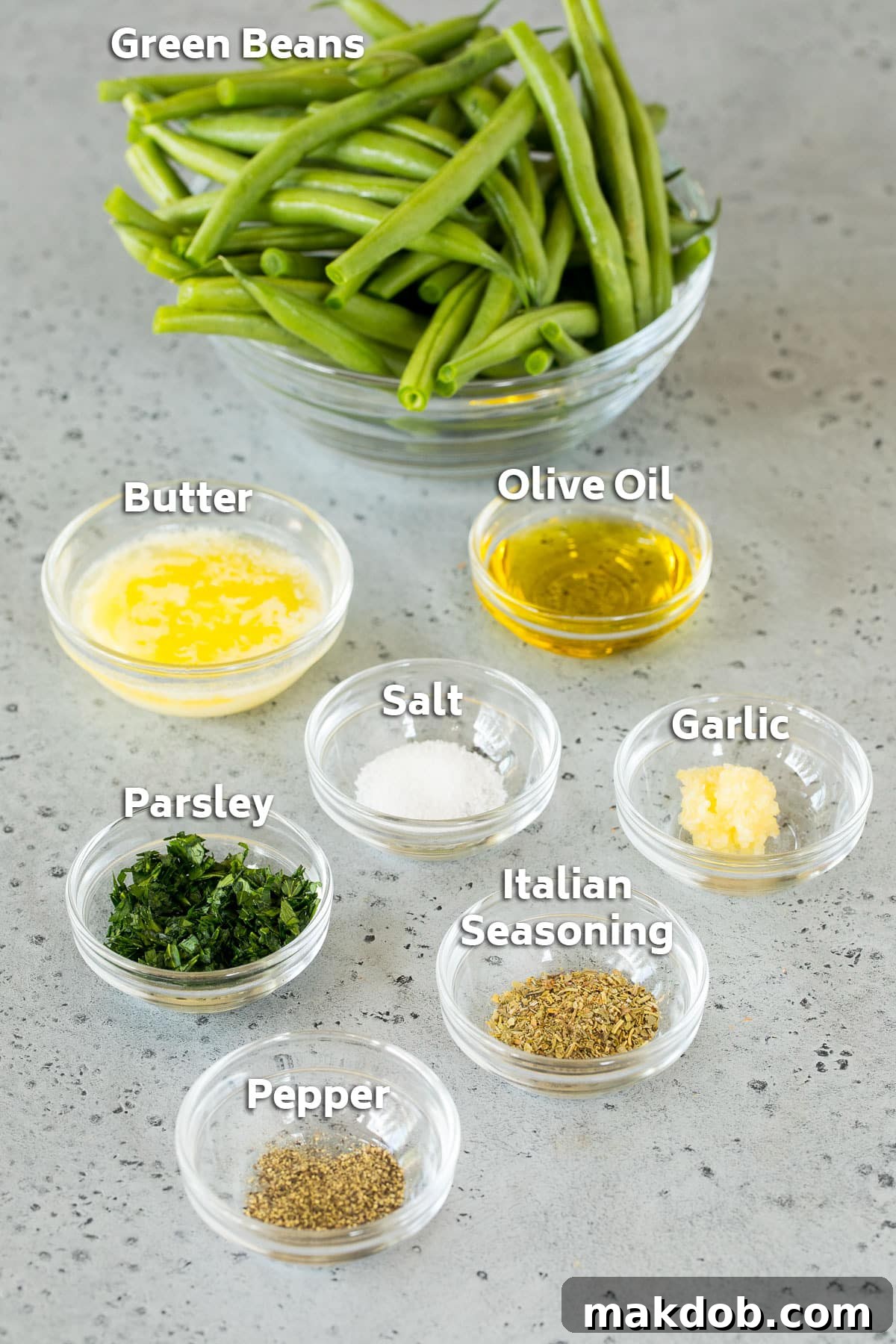 Bowls of ingredients including fresh green beans, olive oil, melted butter, minced garlic, and Italian seasoning.