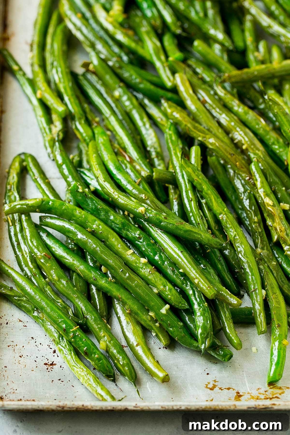 Green beans cooked on a sheet pan, showing their crispy, browned edges.