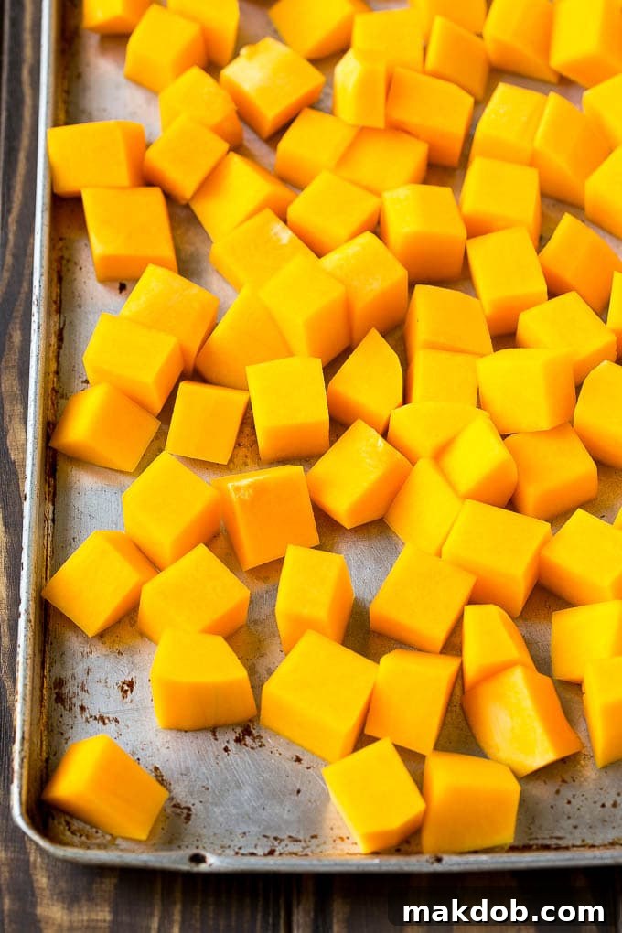 Raw cubed squash on a sheet pan, ready for seasoning and roasting. Perfectly prepared for an easy side dish.