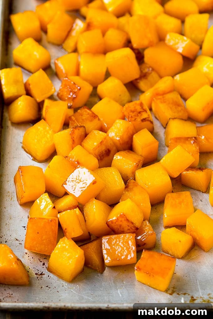 Caramelized cooked butternut squash on a sheet pan, showing its golden-brown perfection after roasting.