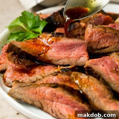 Flank steak marinade being drizzled over meat, highlighting the tender texture.