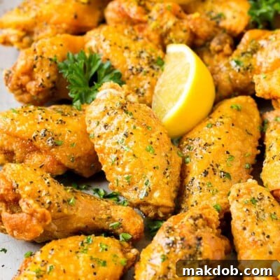Citrus Peppered Wings 7 A tray of lemon pepper wings garnished with parsley and lemon.