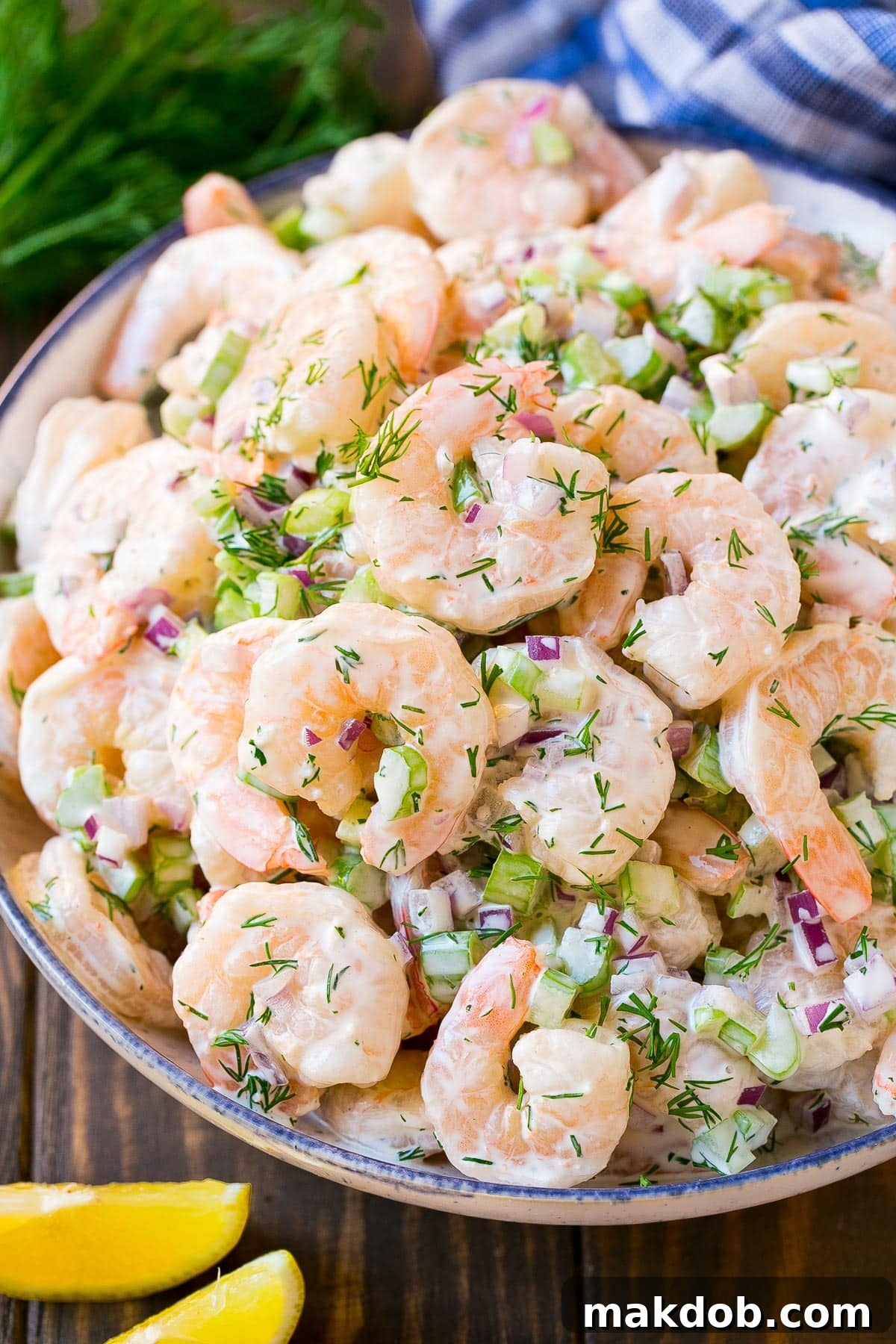 Zesty Shrimp Salad 5 A bowl of shrimp salad with celery and dill, garnished with lemon.