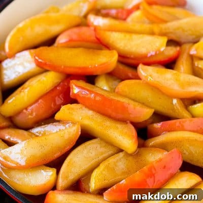 Southern fried apples coated in butter, cinnamon and sugar in a skillet.