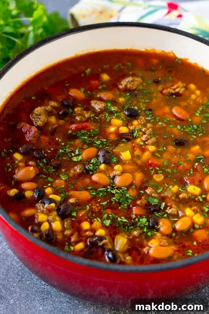 A pot of taco soup with ground beef, peppers, onions, corn, tomatoes and two types of beans.