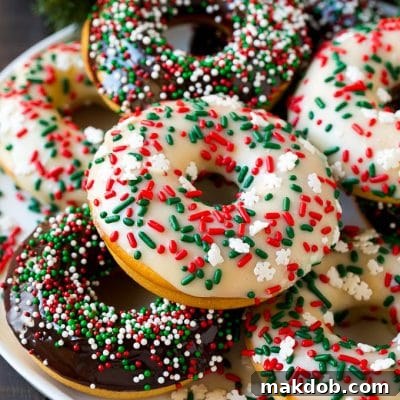 A serving plate of baked donuts frosted in dark and white chocolate and topped with sprinkles.