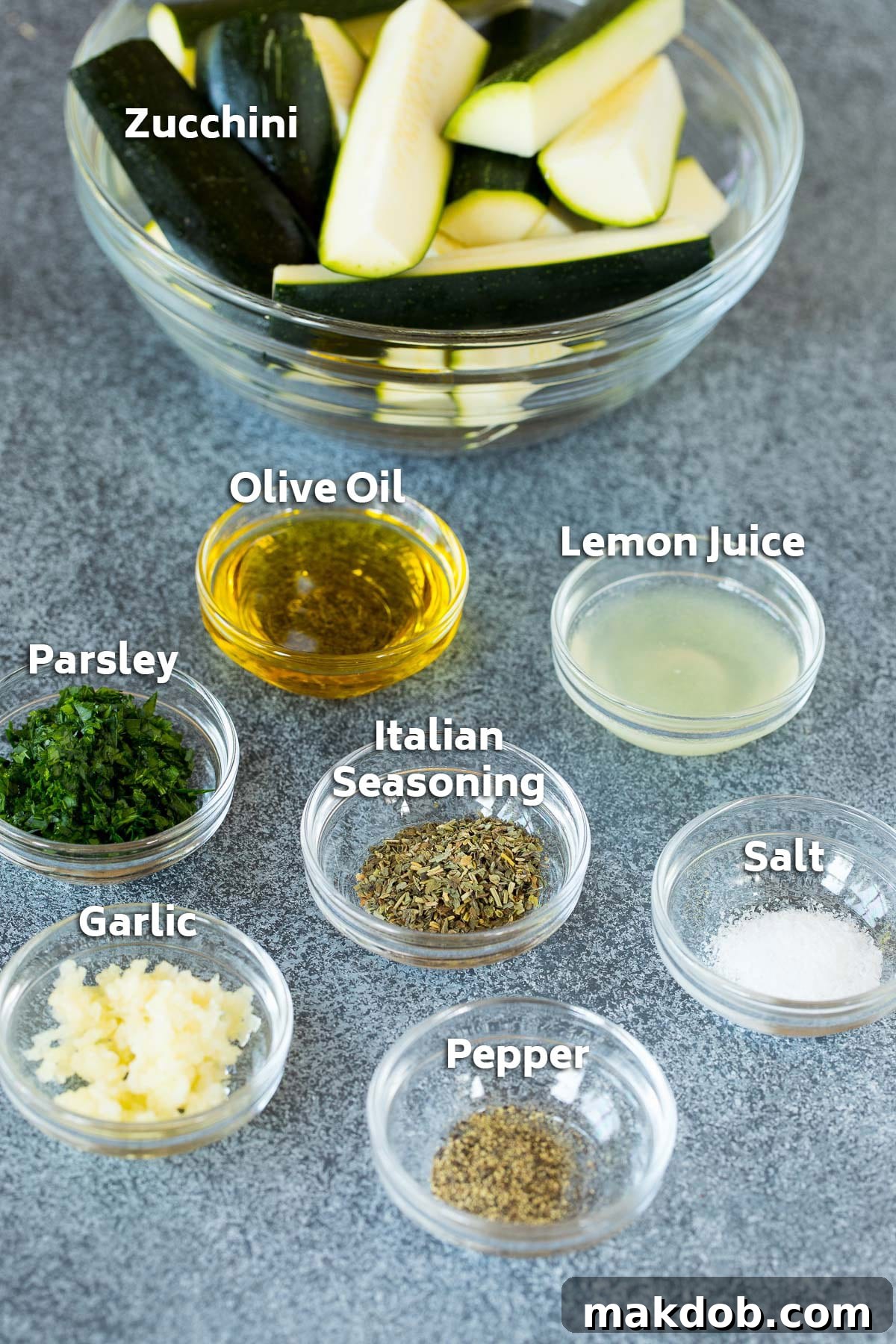 Bowls of fresh ingredients including olive oil, vibrant lemon juice, aromatic herbs, and classic spices, laid out for a grilled zucchini recipe.
