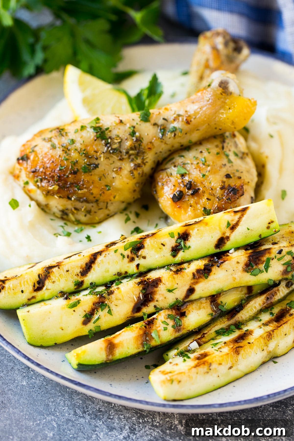 A hearty meal featuring grilled zucchini served alongside creamy mashed potatoes and perfectly cooked chicken, showcasing its versatility as a side dish.