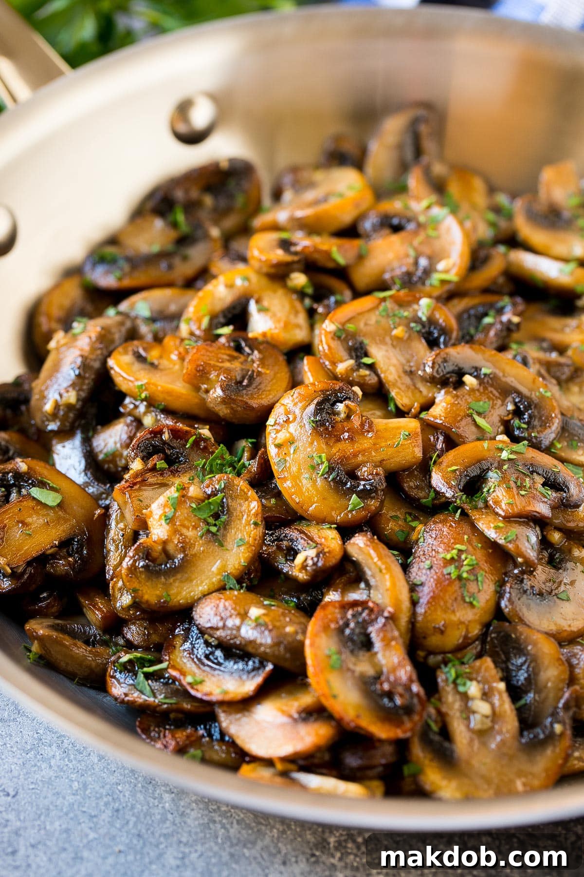 A pan filled with beautifully cooked mushrooms, glistening with butter and garlic, ready to be served.
