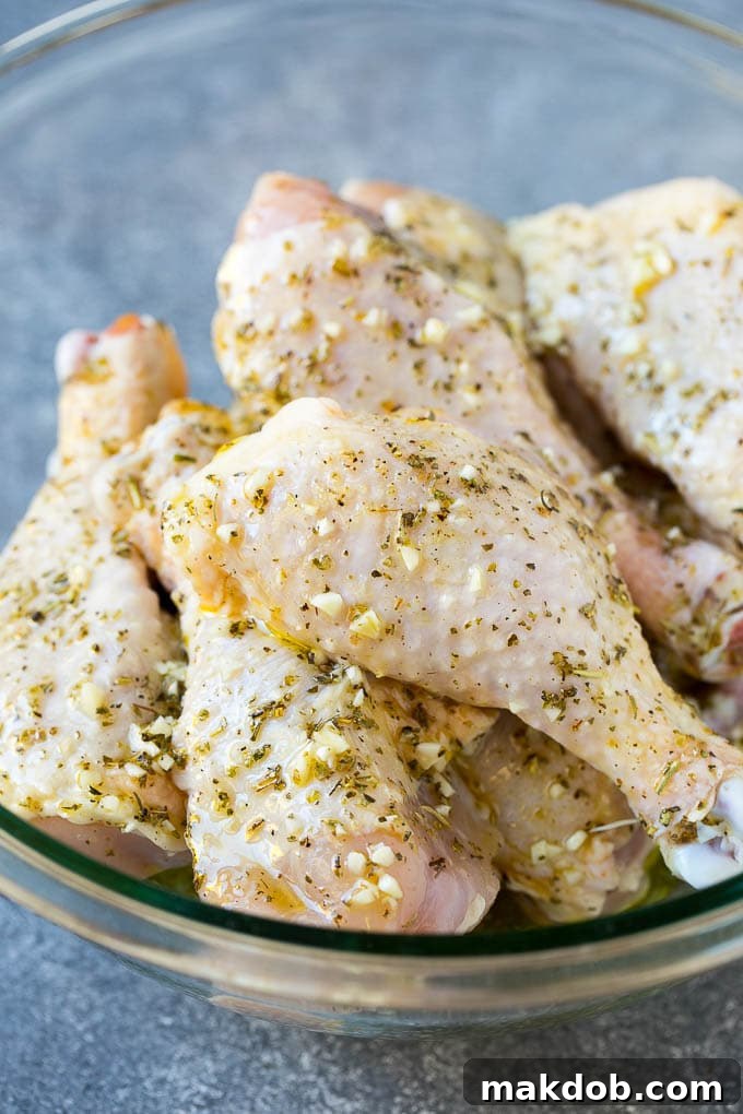 A bowl of chicken legs in a garlic and herb marinade.