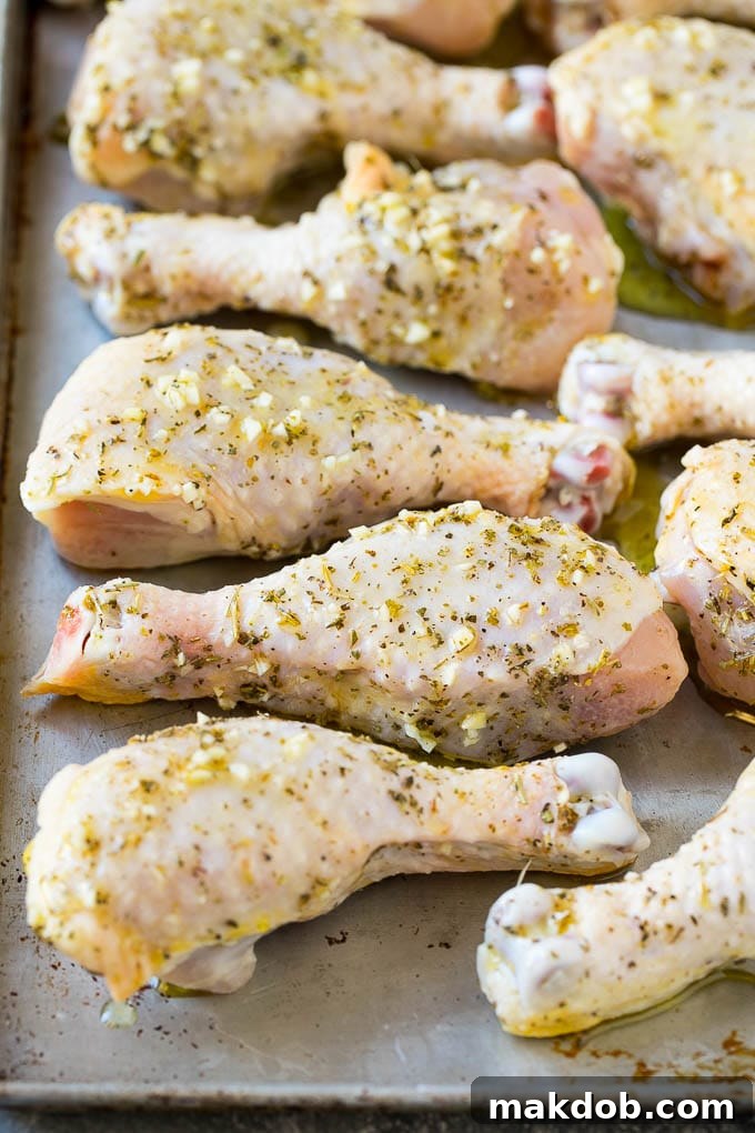Marinated chicken legs on a sheet pan, ready to go into the oven.