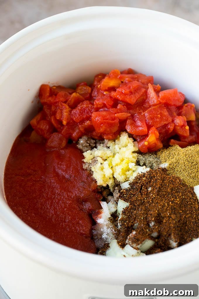 Slow Cooker Chili Recipe | Crock Pot Chili | Beef Chili | Beef and Bean Chili #chili #soup #beef #slowcooker #crockpot #dinner #dinneratthezoo Ground beef, spices, garlic and tomatoes in a slow cooker.