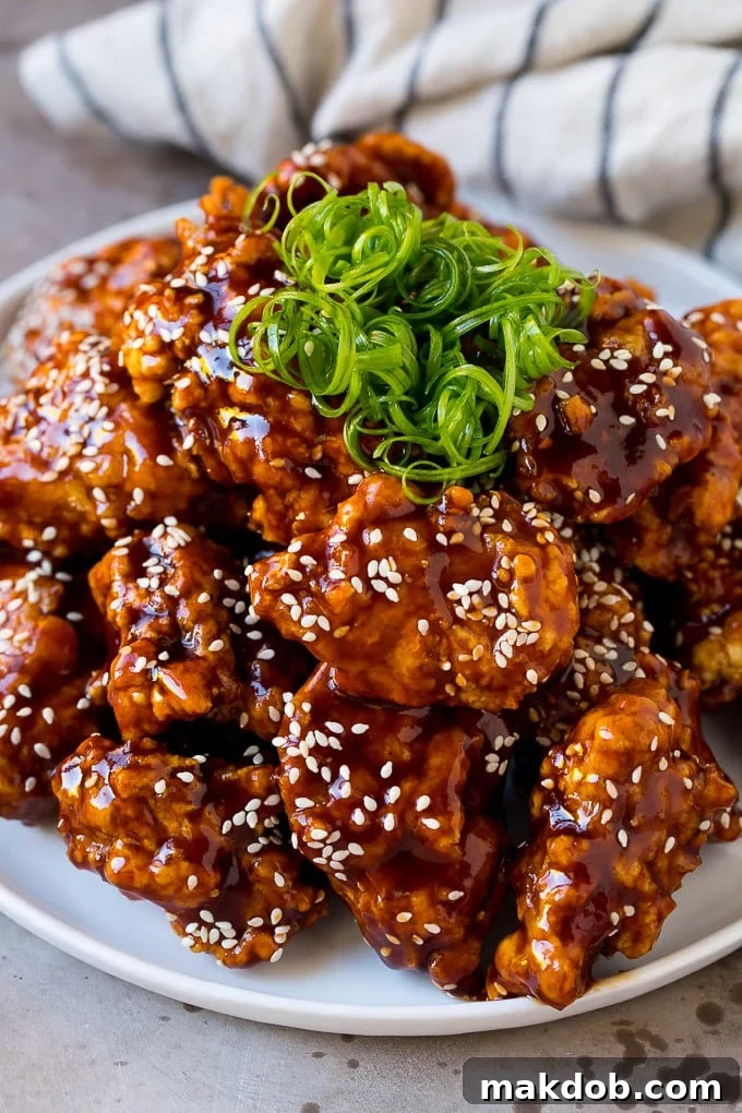 Korean Fried Chicken Recipe | Fried Chicken | Korean Chicken #chicken #friedchicken #appetizer #dinner #dinneratthezoo Korean fried chicken on a serving plate topped with curly green onions.