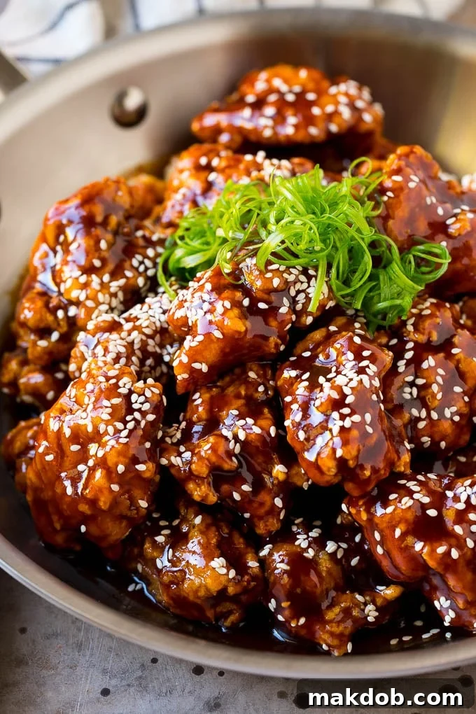Korean Fried Chicken Recipe | Fried Chicken | Korean Chicken #chicken #friedchicken #appetizer #dinner #dinneratthezoo A pan of Korean fried chicken coated in a sweet and spicy sauce then garnished with sesame seeds.