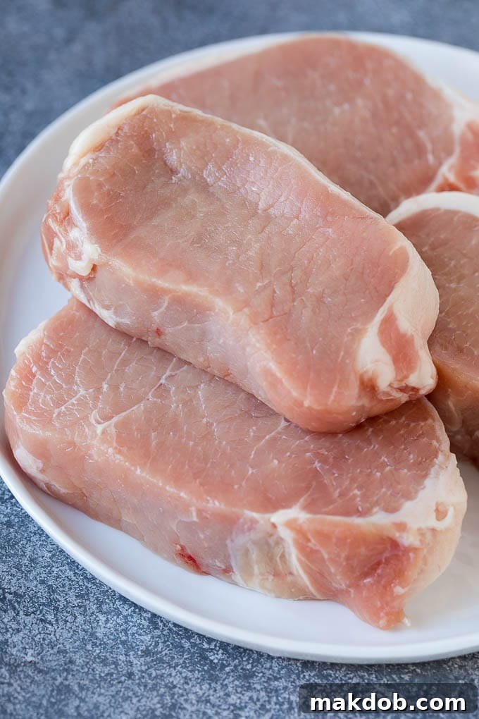 Stuffed Pork Chops Recipe | Boneless Pork Chops Recipe | Italian Pork Chops #pork #porkchops #cheese #lowcarb #dinner #dinneratthezoo Uncooked boneless pork chops on a plate, ready for stuffing.