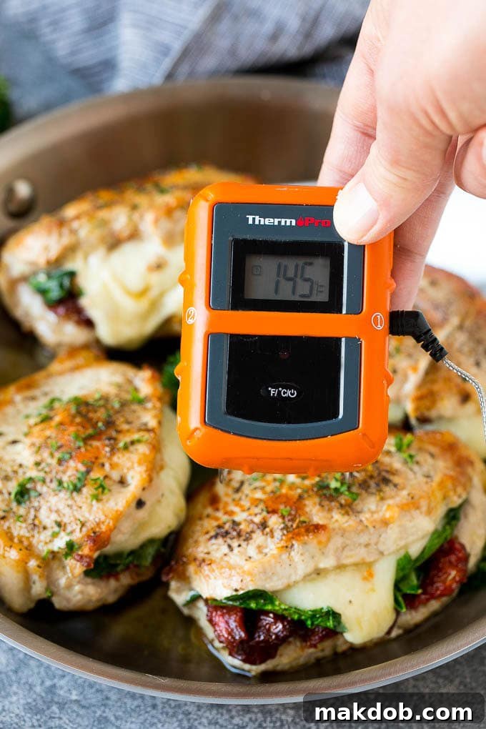 Stuffed Pork Chops Recipe | Boneless Pork Chops Recipe | Italian Pork Chops #pork #porkchops #cheese #lowcarb #dinner #dinneratthezoo A meat thermometer inserted into a stuffed pork chop, showing an internal temperature of 145 degrees F.