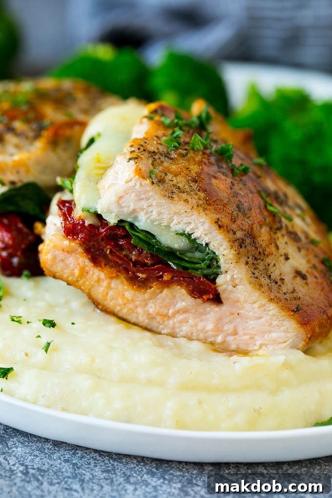 Stuffed Pork Chops Recipe | Boneless Pork Chops Recipe | Italian Pork Chops #pork #porkchops #cheese #lowcarb #dinner #dinneratthezoo A cross-section view of a succulent stuffed pork chop, served alongside fluffy mashed potatoes and vibrant roasted broccoli.
