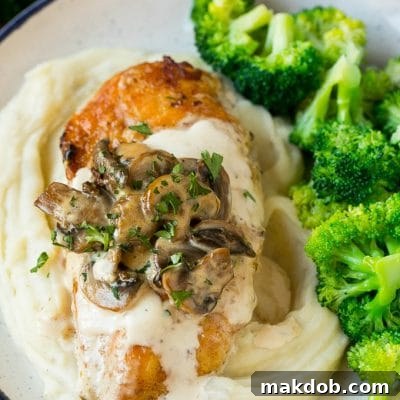 Instant Pot chicken with creamy mushroom sauce served over mashed potatoes with a side of broccoli.