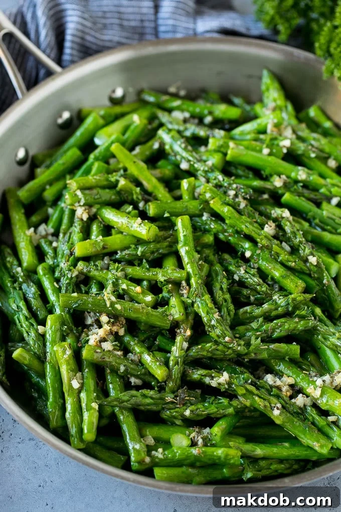 Sauteed asparagus with butter, garlic and herbs in a skillet.