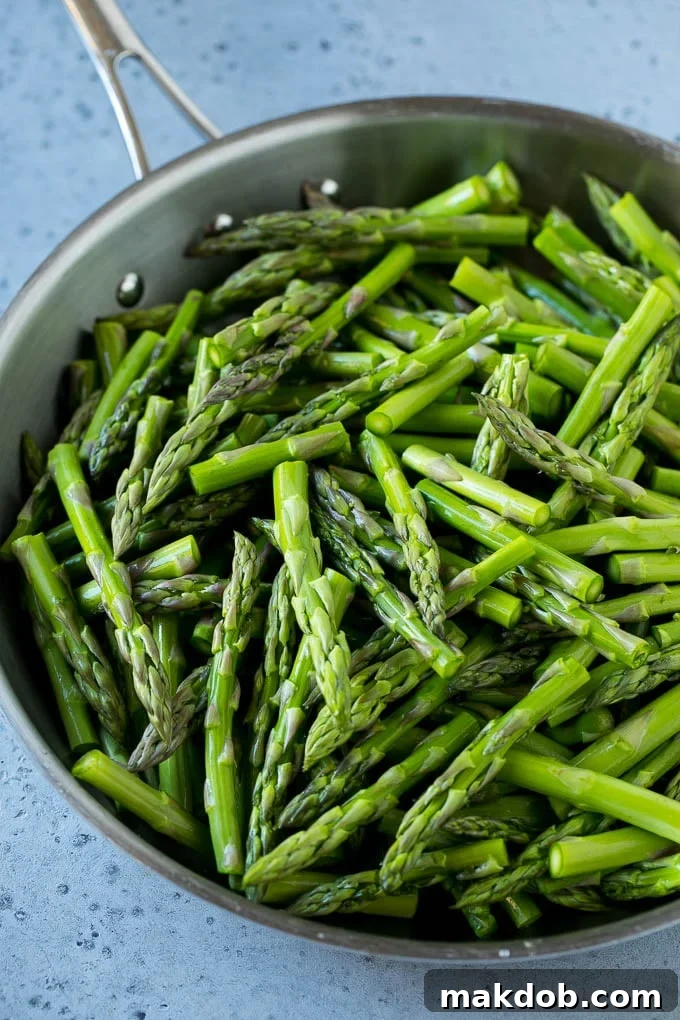 Raw chopped asparagus stalks in a frying pan.