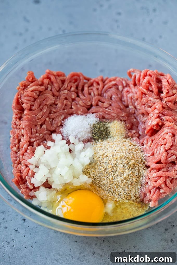 Sweet and Sour Meatballs Recipe | Slow Cooker Meatballs | Crockpot Meatballs | Cocktail Meatballs #meatballs #beef #slowcooker #crockpot #dinner #appetizer #dinneratthezoo Ground beef, onion, breadcrumbs and seasonings in a bowl.