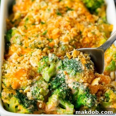 A pan of broccoli casserole with a serving spoon in it.