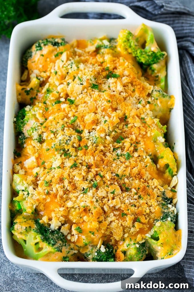 A pan of hot, bubbly broccoli casserole, freshly baked and topped with golden crackers, melted cheese, and a garnish of fresh parsley.