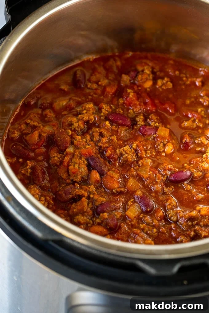 An Instant Pot filled with richly colored beef chili, ready to be served.