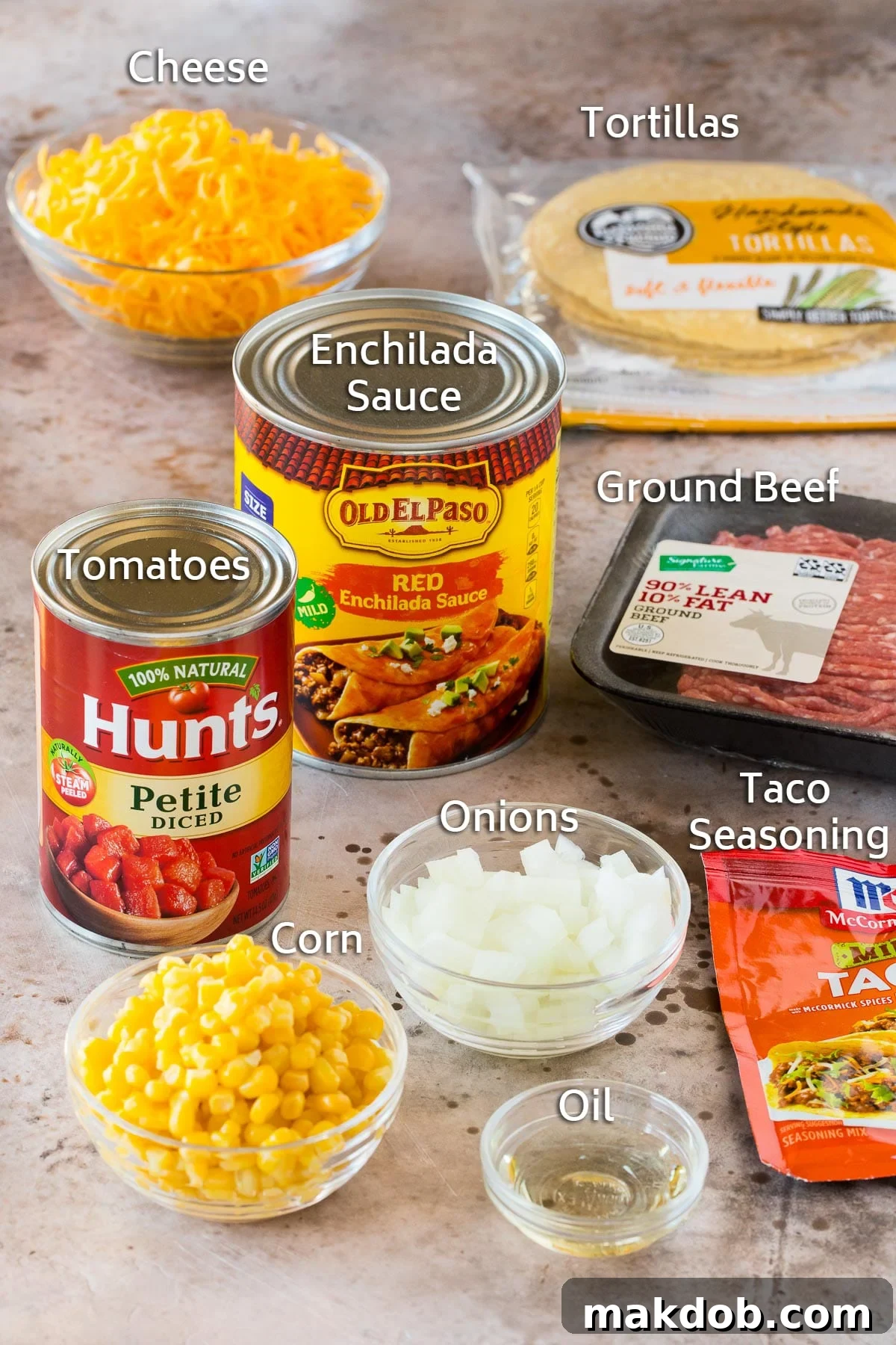Zesty Mexican Layer Bake 3 Ingredients for Mexican casserole laid out, including uncooked ground beef, corn tortillas, taco seasoning, canned diced tomatoes, frozen corn, and shredded cheese.
