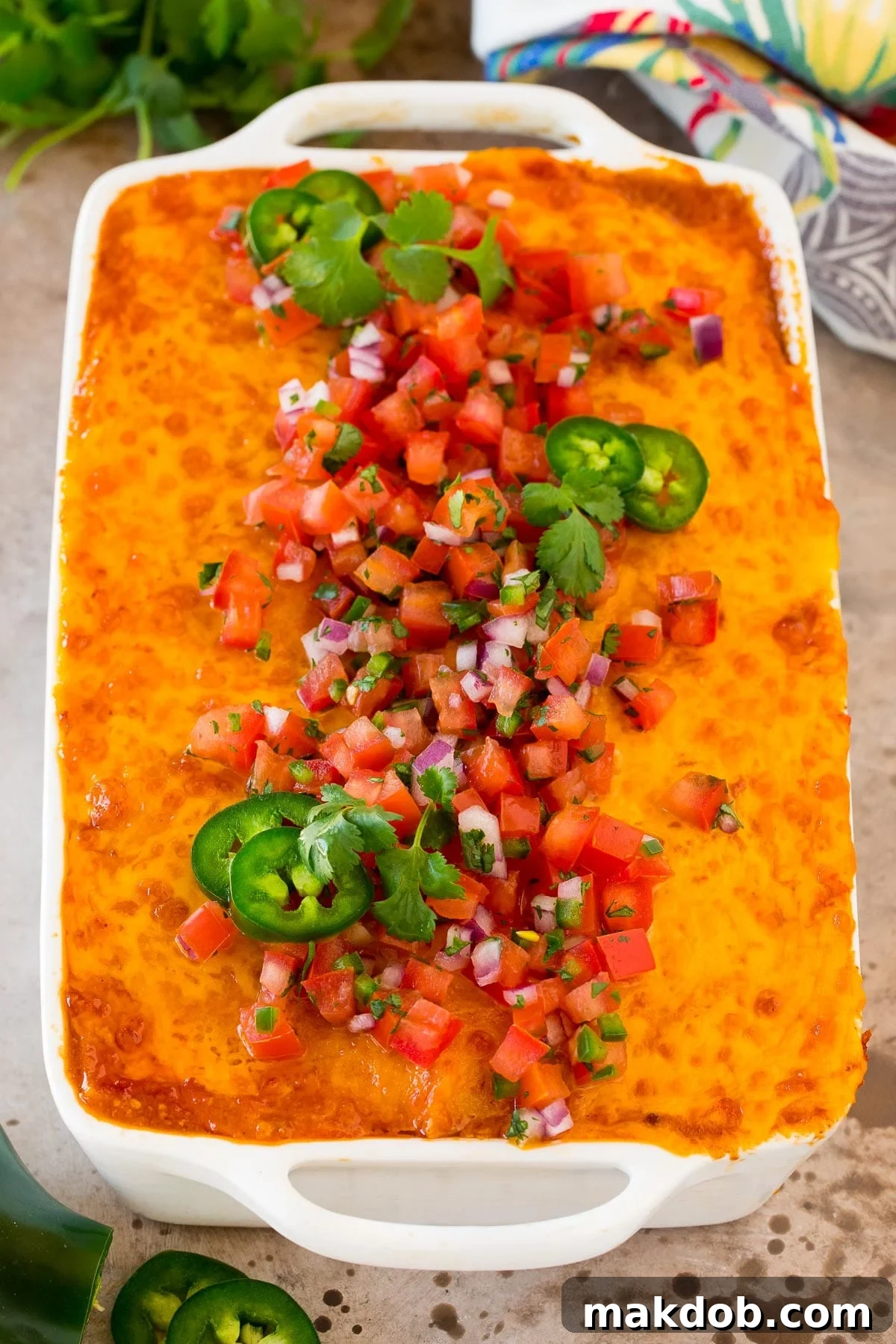 Zesty Mexican Layer Bake 6 A vibrant Mexican casserole in a baking dish, freshly baked and topped with bright red salsa and fresh green cilantro, ready to be served.