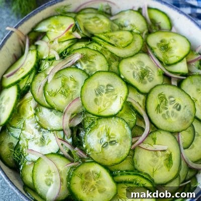 Cucumber salad in a serving bowl with sliced English cucumbers, red onion and fresh dill.