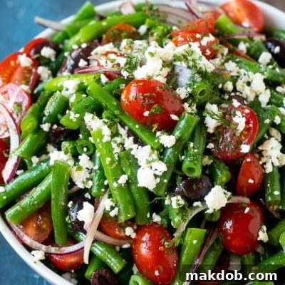 Vibrant Green Bean Medley 2 A bowl of green bean salad made with feta cheese, tomatoes, red onion and kalamata olives.