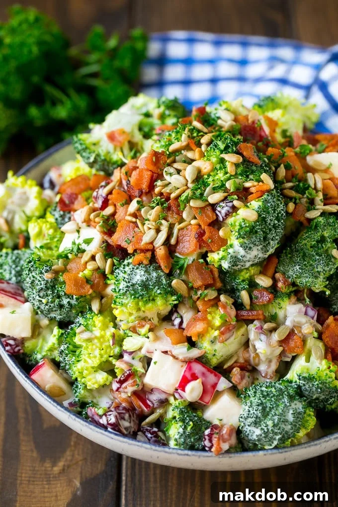 Broccoli Salad Recipe | Creamy Broccoli Salad | Bacon Broccoli Salad #salad #broccoli #bacon #apple #dinneratthezoo #sidedish A bowl of broccoli salad made with dried cranberries, apples, bacon and sunflower seeds in a creamy dressing.