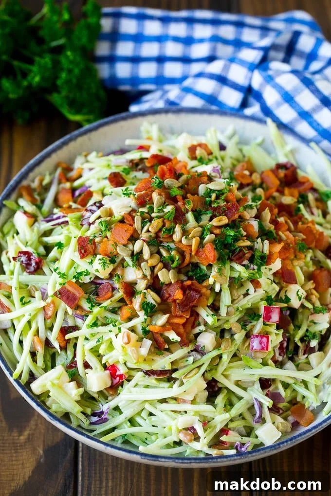A bowl of broccoli slaw tossed in a creamy dressing with bacon and sunflower seeds.