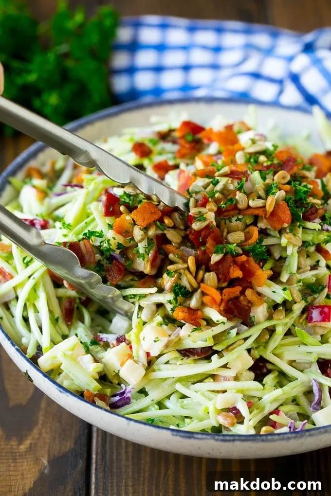 Tongs serving up a portion of broccoli slaw.